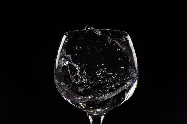Water splashing out of a tall wine glass - Foto, Imagen