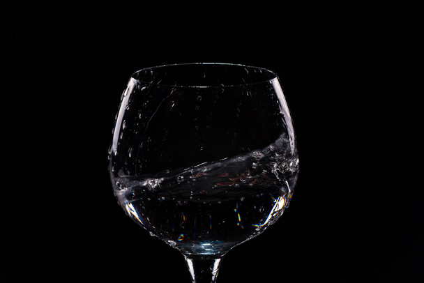 Water splashing out of a tall wine glass - Foto, Imagen