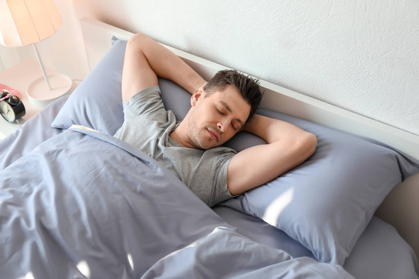 Young man sleeping in bed at home - Photo, image