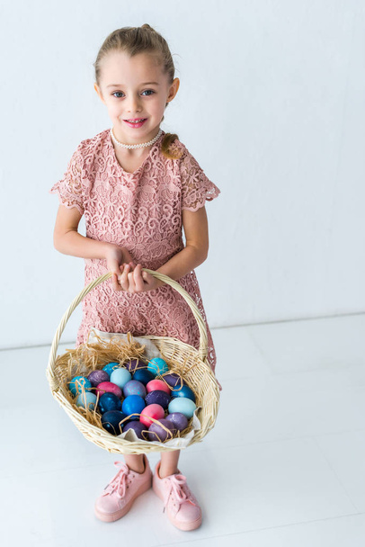 子供の女の子バスケットでイースターの卵を保持 - 写真・画像