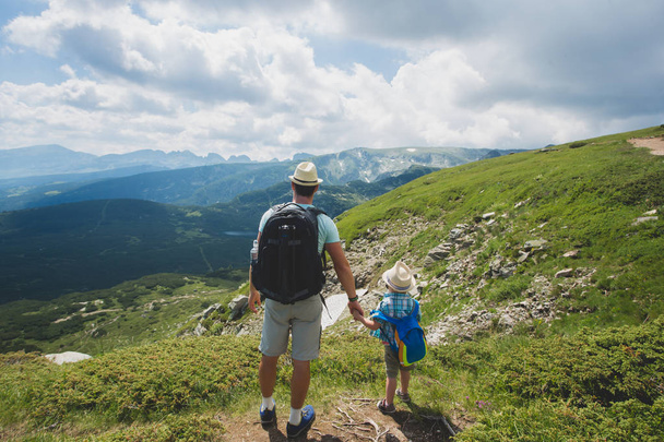 Father and son traveling in Rila mountains Bulgaria - 写真・画像