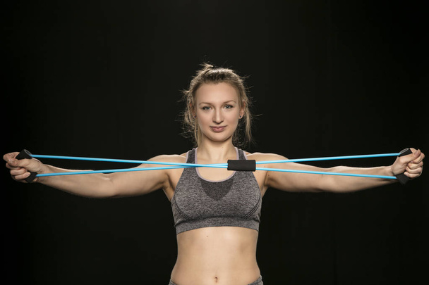 athletic woman stretching elastic rubber in front of herself, cl - Fotografie, Obrázek
