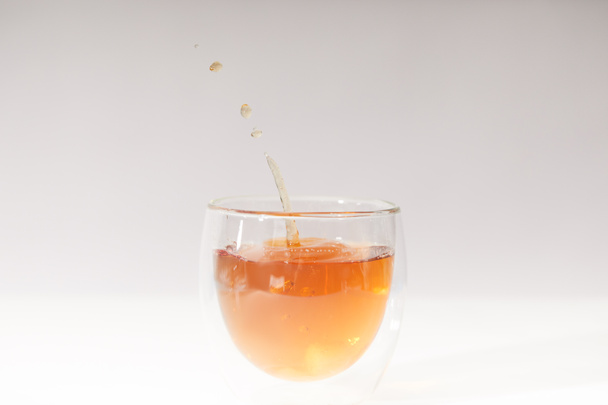 close-up view of pouring fresh hot tea in glass cup on grey - Photo, Image
