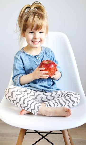 Portrait of Little Girl Eating Breakfast at Home Fruits Apple Summer Concept of Healthy Food for Children - Foto, immagini