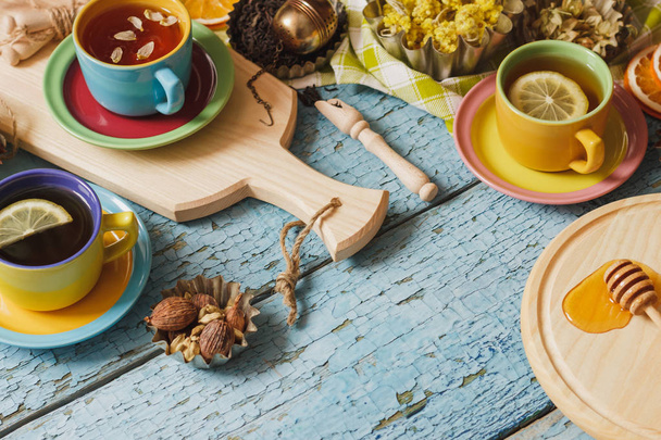 Cups with herbal tea and pieces of lemon, dried herbs and different decorations - Foto, afbeelding