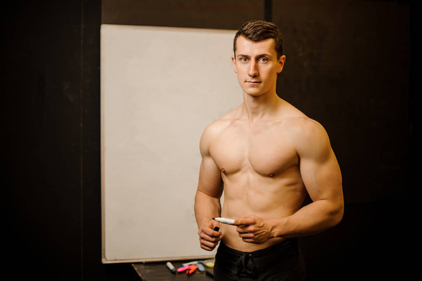 Sexy muscular man practicing crossfit stands near the board - Valokuva, kuva