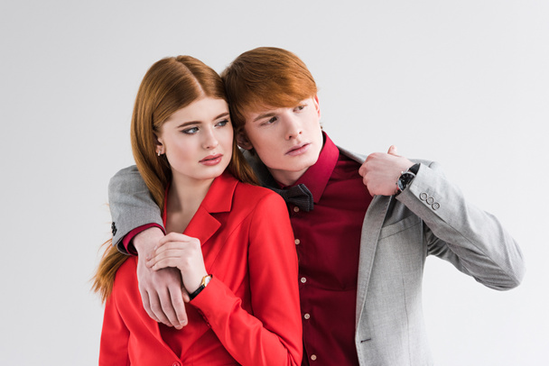 Young couple of fashion models with wristwatches isolated on grey - Foto, imagen