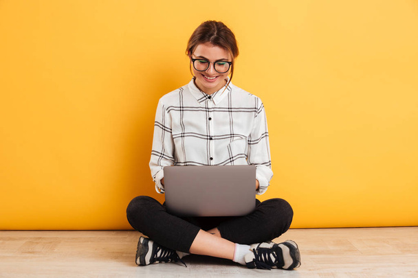 Attractive woman with beautiful smile working or typing on lapto - Φωτογραφία, εικόνα
