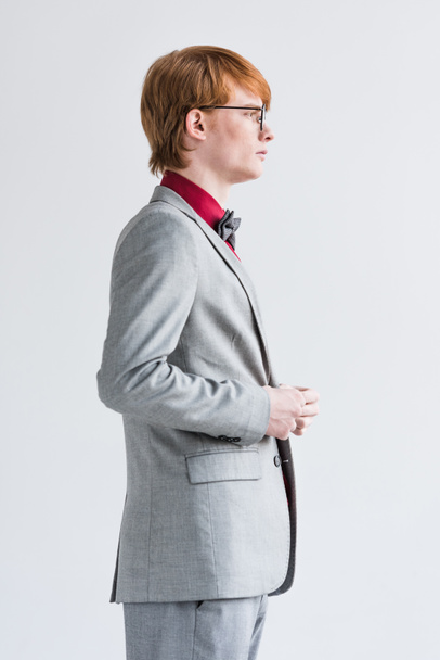 Profile of male fashion model in eyeglasses dressed in suit isolated on grey - Фото, зображення