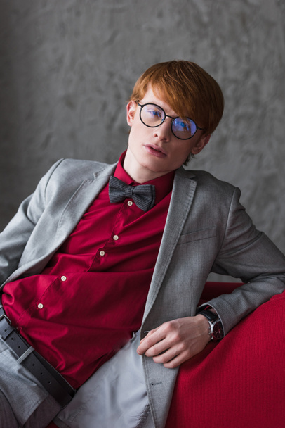 Male fashion model in eyeglasses dressed in suit and bow tie - Fotoğraf, Görsel