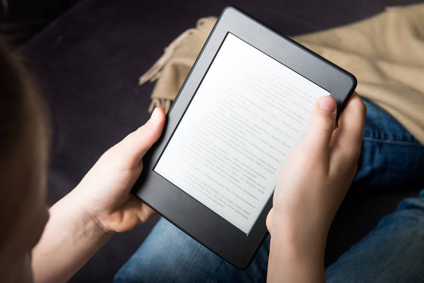 Girl is reading ebook on digital tablet device - Foto, imagen