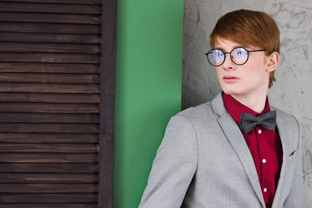 Male fashion model in eyeglasses standing in front of wall  - Fotografie, Obrázek
