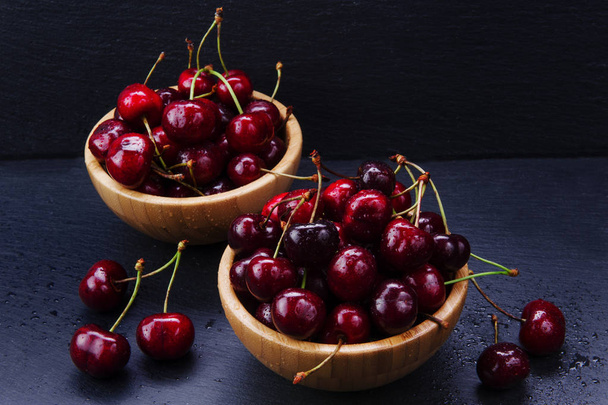 Słodkie czerwone wiśnie w drewniane miski - Zdjęcie, obraz
