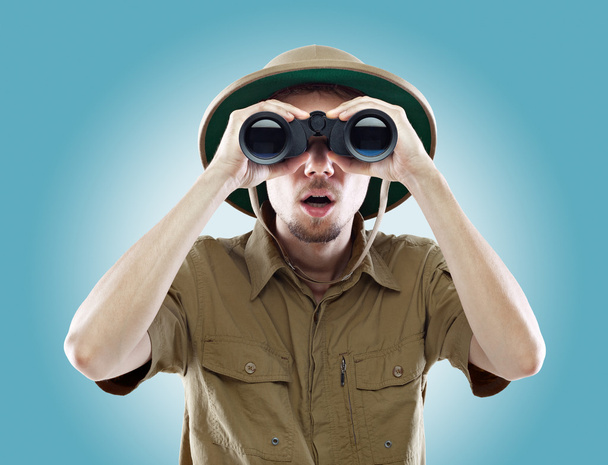 Surprised explorer looking through binoculars - Photo, Image