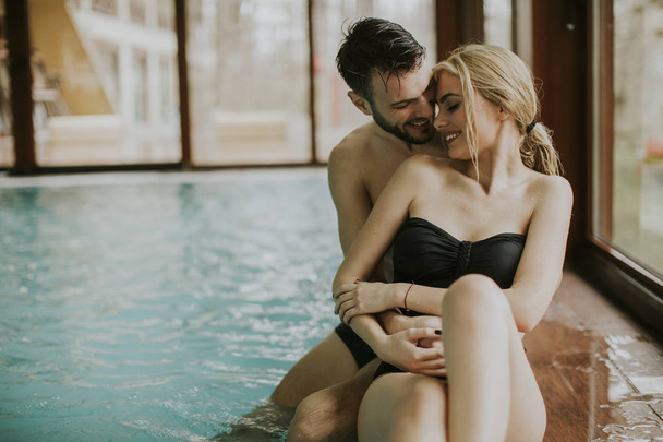 Любящие пары отдыхают в спа-центре у бассейна
 - Фото, изображение