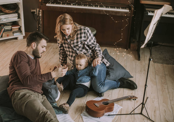 Szczęśliwa rodzina młodych, grając na podłodze w pokoju - Zdjęcie, obraz