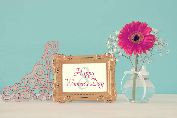 Изображение концепции Международного женского дня с красивым цветком в вазе на деревянном столе
. - Фото, изображение