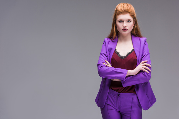 Young stylish female model dressed in purple suit isolated on grey - Foto, immagini