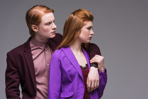Side view of young fashion models couple isolated on grey - Foto, afbeelding