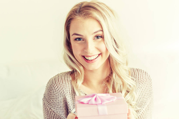 happy young woman with gift box at home - Valokuva, kuva