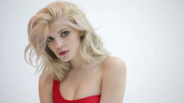 Sexy krásná blondýnka pózuje v červených plavkách na bílé studio - Záběry, video