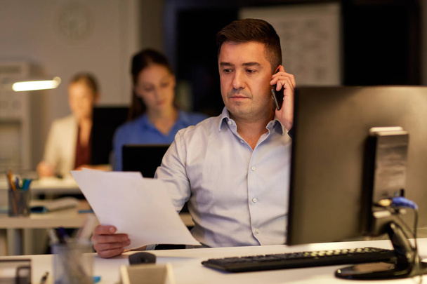 businessman calling on sartphone at night office - Zdjęcie, obraz