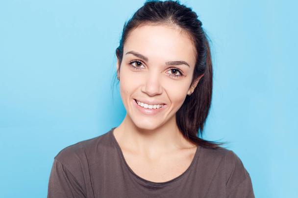 Beautiful smiling woman on blue background. - Фото, зображення