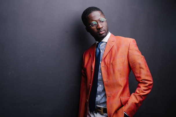 Confident young African man posing in orange jacket  - Fotó, kép