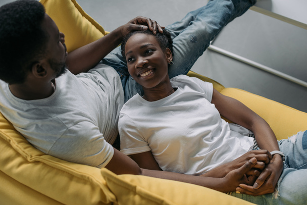 visão de alto ângulo de feliz jovem casal afro-americano passar tempo juntos em casa
 - Foto, Imagem