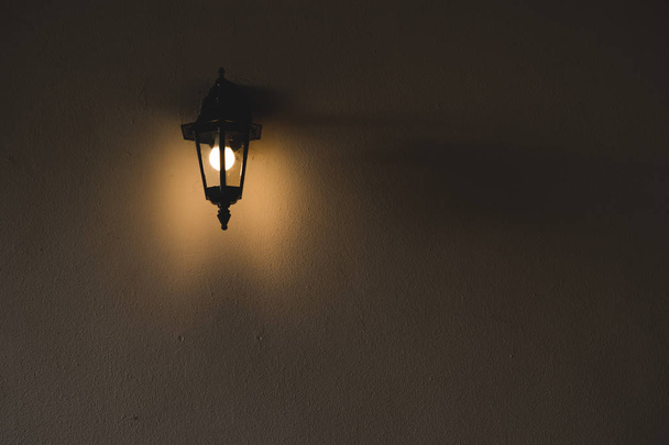 Lamppu lampetit seinällä pimeydessä
 - Valokuva, kuva