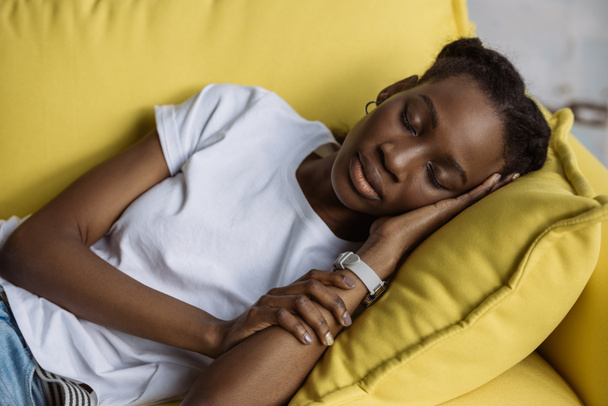 beautiful young african american woman sleeping on sofa at home - Foto, imagen