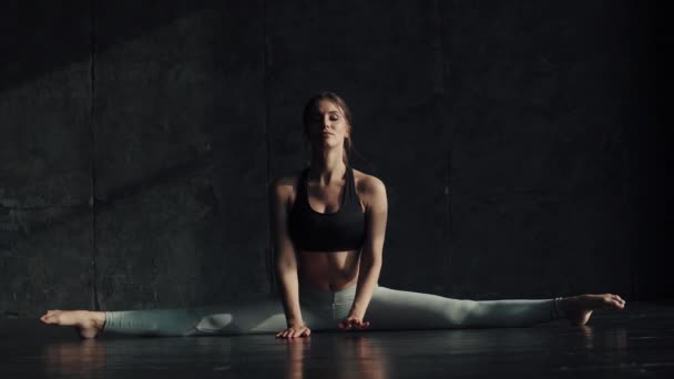 girl doing stretching sitting on a string. gymnast for training. attractive young woman in sportswear is engaged in yoga. - Footage, Video