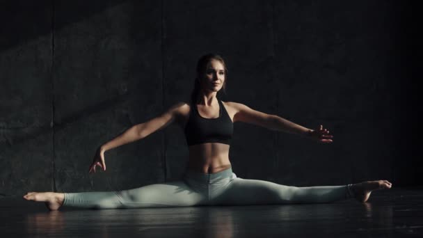 Mädchen beim Stretching auf einer Schnur sitzend. Turner zum Training. attraktive junge Frau in Sportbekleidung betreibt Yoga. - Filmmaterial, Video