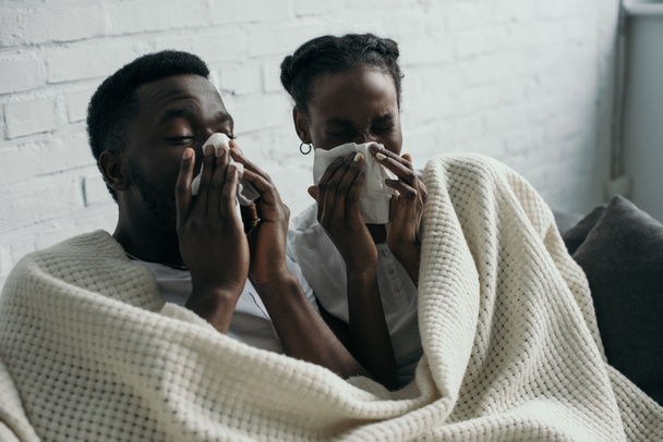young african american couple holding paper napkins while having flu together at home - Foto, Bild
