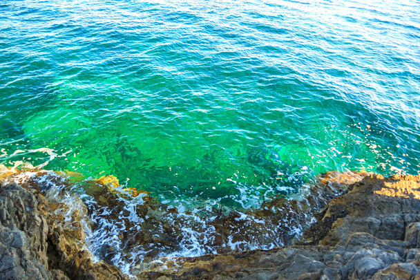 mar tranquilo surf cerca de las rocas
 - Foto, Imagen