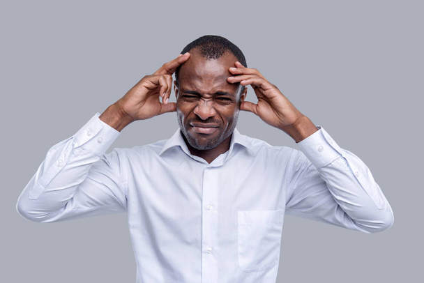 Unsmiling afro-american man having a terrible headache - Фото, зображення