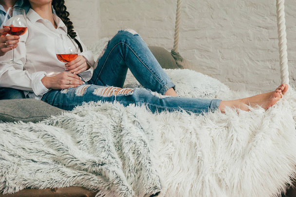 A young couple in jeans with wine on a bed - Foto, afbeelding
