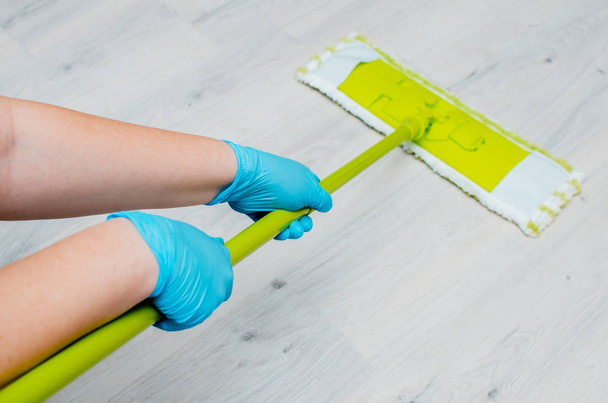 Sprzątanie w mieszkaniu. Kobiecych rąk w niebieski gumowe rękawiczki. C - Zdjęcie, obraz