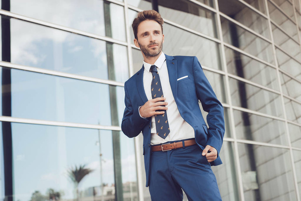 Guapo modelo masculino posando usando un traje azul. - Foto, Imagen