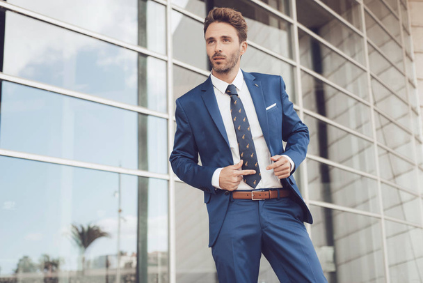 Handsome male model posing wearing a blue suit. - Foto, imagen