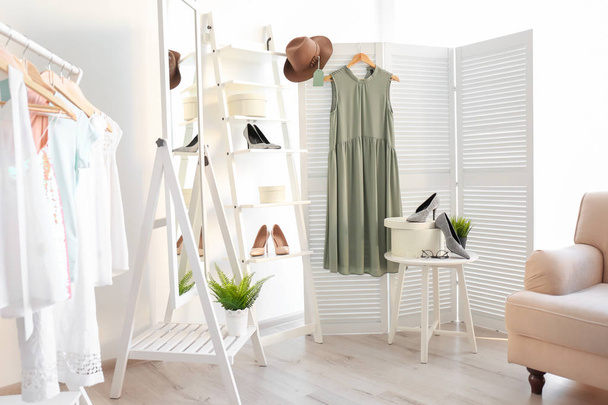 Stylish clothes and shoes in dressing room. Fashionable wardrobe - Фото, зображення