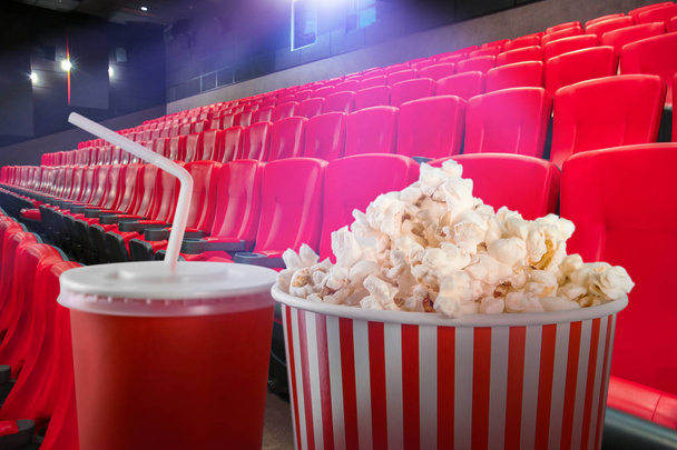 Tasty popcorn and cup of drink in cinema - Photo, Image