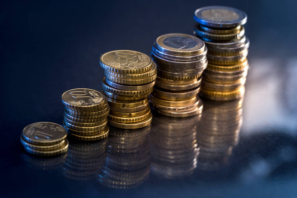 Ersparnisse, wachsende Säulen von Goldmünzen isoliert auf schwarzem Hintergrund - Foto, Bild