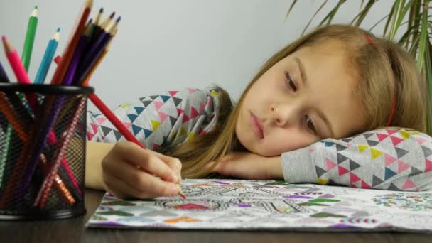 Het gezicht van een trieste meisje tekenen met kleurpotloden. Moe kind rusten kleuren anti stress boek. - Video