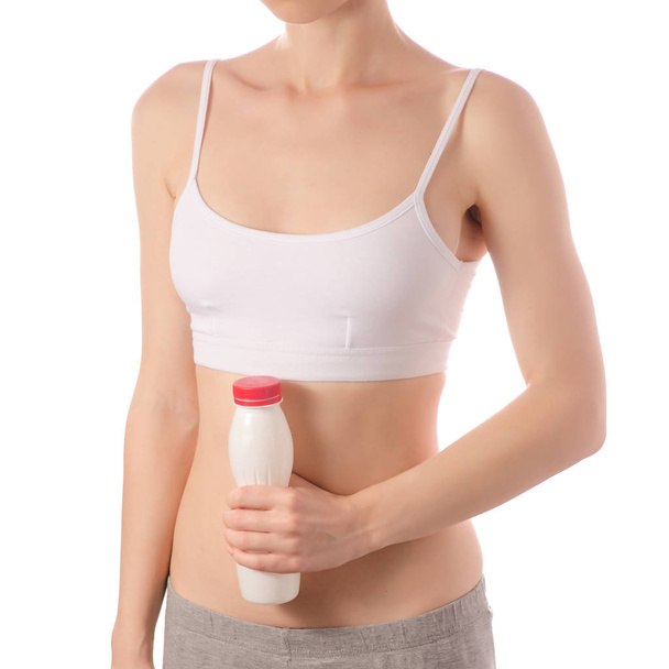 Young beautiful woman in a white T-shirt top stomach in hands a bottle of yogurt beauty health - Fotó, kép