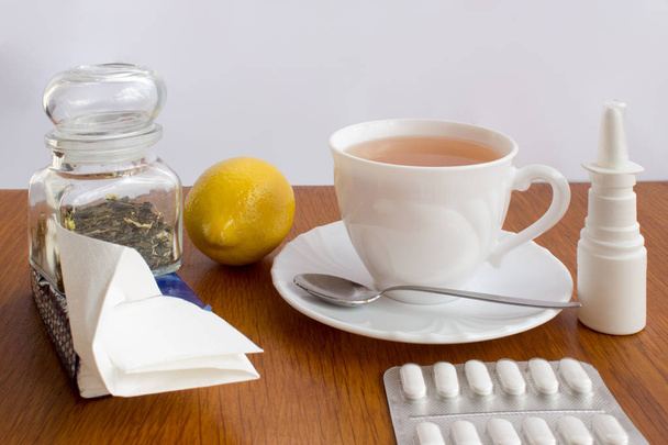 Ένα φλιτζάνι τσάι με φάρμακα και ένα μαντήλι - Φωτογραφία, εικόνα