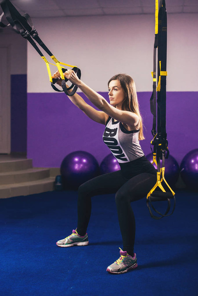 Attractive Woman Does Crossfit Push Ups With Trx Fitness Straps In The Gym's Studio - Foto, imagen
