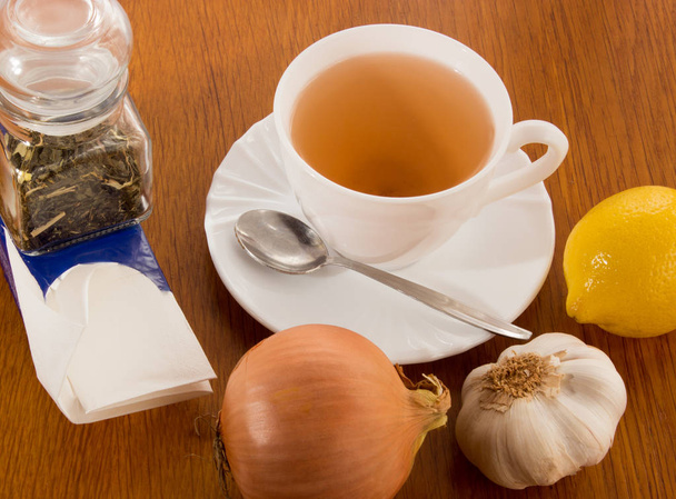 Šálek čaje, kapesníky, cibule, česnek, citron - Fotografie, Obrázek