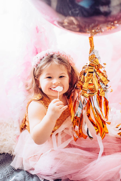 Το χαριτωμένο μικρό κορίτσι δωμάτιο στο πάρτι γενεθλίων με μπαλόνια. - Φωτογραφία, εικόνα
