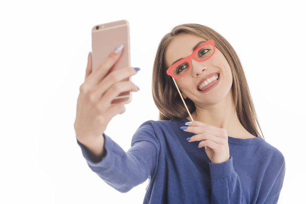 Beautiful girl taking selfie with paper glasses  - Фото, изображение